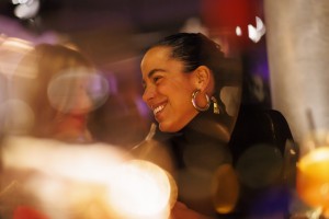 Person smiling in a warmly lit dining space