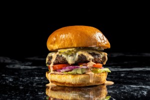 juicy cheeseburger on a black marble table