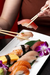 Person eating sushi with chopsticks
